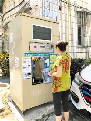 5月24日，瓊山區(qū)上丹花苑小區(qū)居民陳女士在使用共享凈水機取水。 本報記者 陳歆卓 攝